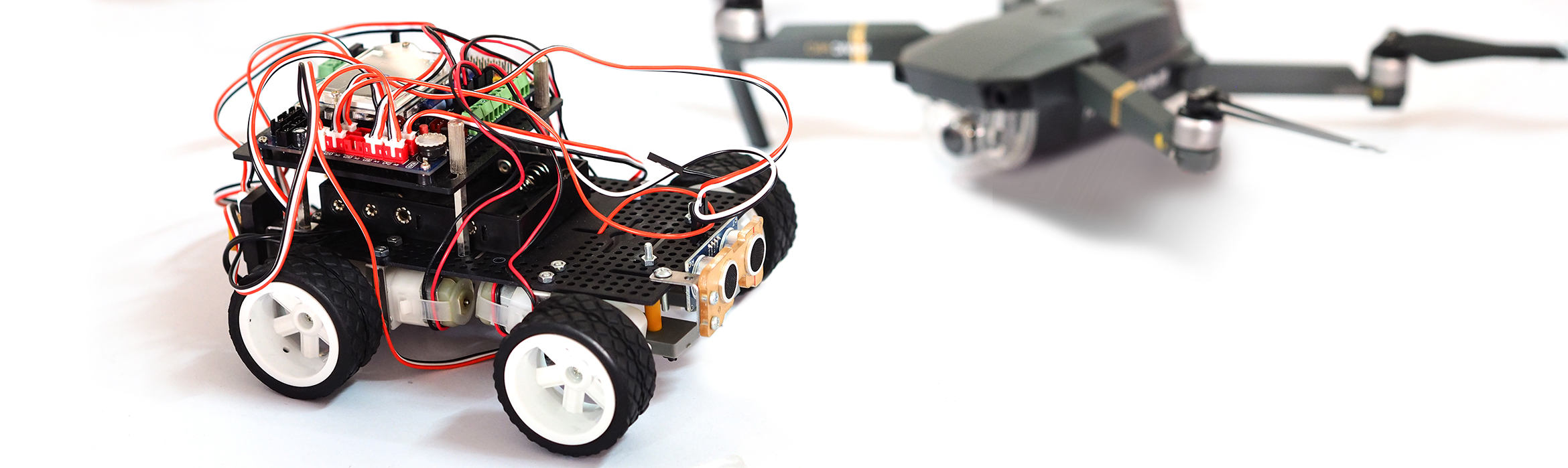 La imagen muestra un dron así como un vehículo formado por diversos componentes electrónicos